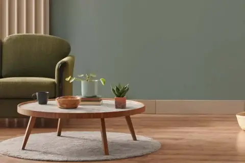 Gemütliches Wohnzimmer mit Sofa, Couchtisch und Pflanzen. Die Einrichtung ist in **neutralen Farben** gehalten, was eine beruhigende Atmosphäre schafft.