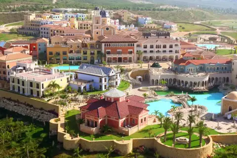 Vista aérea del hotel Villaitana en Benidorm, con sus coloridos edificios, piscinas y exuberante vegetación.