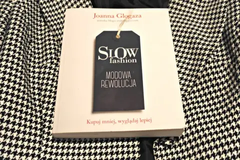 Książka "Slow fashion. Modowa rewolucja" Joanny Glogazy na tle wzorzystej tkaniny. Inspiracja dla polskich marek slow fashion.