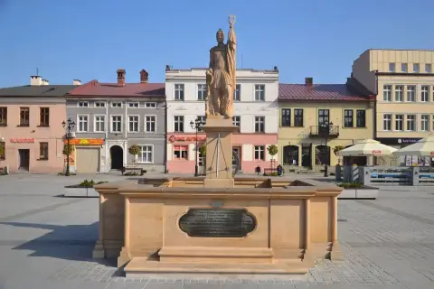 Pomnik na żywiec rynku, z kolorowymi kamienicami w tle.