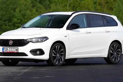 Biały Fiat Tipo kombi na tle zieleni. Wiele osób szuka takich aut, sprawdzając fiat tipo opinie.
