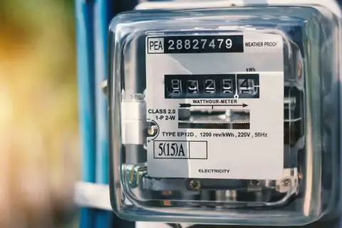 Licznik energii elektrycznej pokazuje zużycie w **kilowatogodzinach**. Widoczny jest numer seryjny i dane techniczne urządzenia.