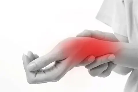 Dłoń z zaczerwienionym obszarem bólu nadgarstka bez powodu.