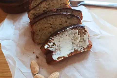 Pyszny chlebek bananowy z airfryera, pokrojony w plastry, jeden posmarowany masłem. Idealny na śniadanie.