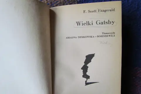 Strona tytułowa "Wielkiego Gatsby'ego" F. Scotta Fitzgeralda. Czarno-biała grafika profilu twarzy.