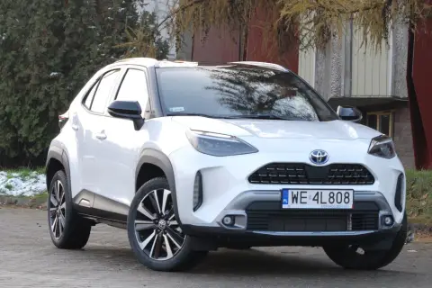 Biały Toyota Yaris Cross 2025 z czarnymi dodatkami, zaparkowany na zewnątrz.