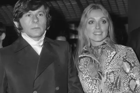Roman Polański i jego żona Sharon Tate, uśmiechnięci, pozują do zdjęcia.