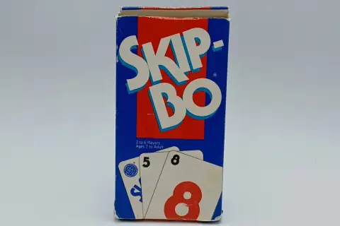 Pudełko gry karcianej Skip-Bo, z widocznymi kartami 5 i 8. Idealne do nauki zasad gry.