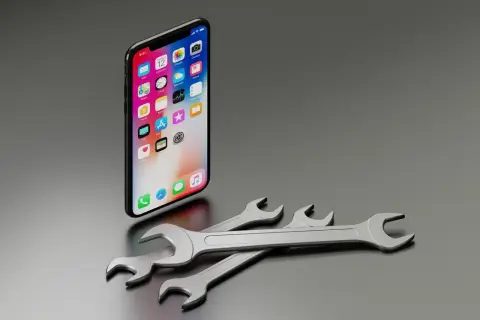 iPhone z ikonami aplikacji na ekranie i kluczami. Czy to jest to, co oznacza "ios co to"?