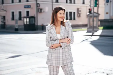Kobieta w kraciastym garniturze, idealna odpowiedź na pytanie: jaka marynarka do spodni w kratę. Stylowy komplet na ulicy.