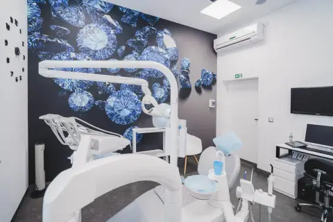 Nowoczesny gabinet stomatologiczny z fotelem dentystycznym i tapetą z niebieskimi diamentami.
