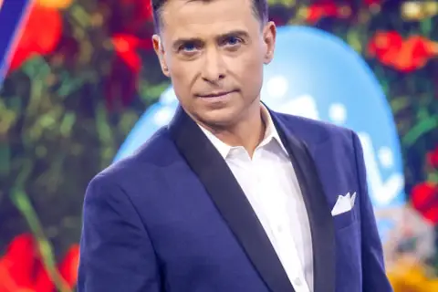 Kacper Kuszewski w granatowej marynarce z czarnym wyłogiem i białą koszulą.