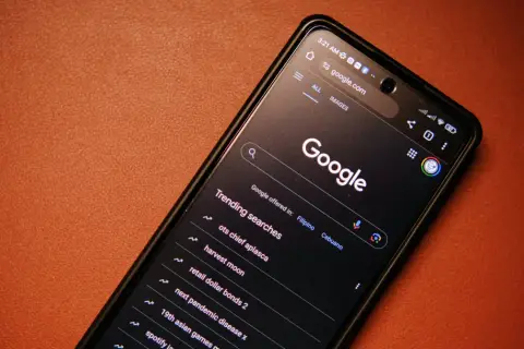 Telefon z ciemnym motywem Google, wyświetlający wyszukiwane hasła, w tym "next pandemic disease x". Ustawienia safesearch są aktywne.