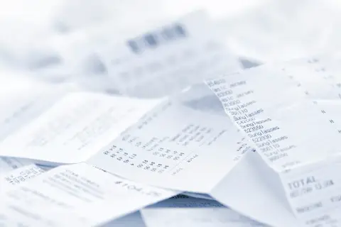 Stos papierowych paragonów, każdy z nich to faktura do paragonu, dokumentująca zakupy.