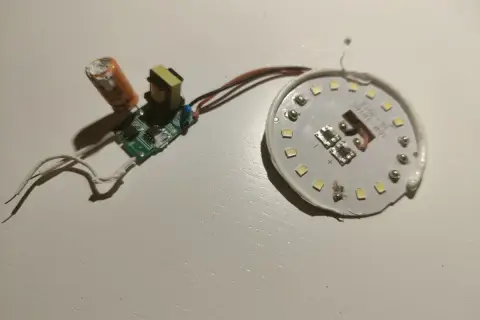 Rozłożona żarówka LED z widocznym modułem zasilania i płytką z diodami. Może to być pomocne, gdy zastanawiasz się, jak naprawić żarówkę LED.