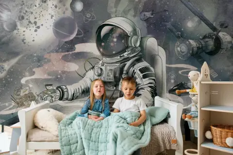 Dzieci siedzą pod kołdrą na łóżku, a za nimi wspaniała tapeta kosmos dla dzieci z astronautą i planetami.