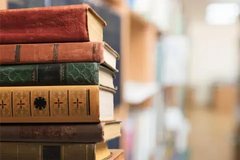 Stos starych książek. W powieści epistolarnej listy miłosne budują intymność i ujawniają motywacje postaci.