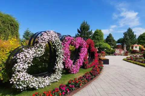 Trzy serca z kwiatów: białe, różowe i czerwone, ozdabiają park podczas festiwalu kwiatów.