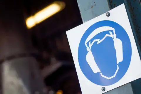 Señal de protección auditiva, indicando la necesidad de usar tapones o cascos para reducir el nivel sonoro en el área.
