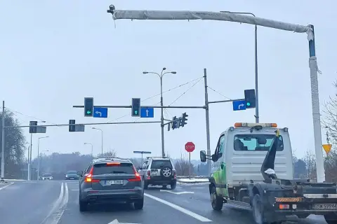 Na skrzyżowaniu widać różne rodzaje kamer monitorujących ruch. Samochody czekają na zielone światło.