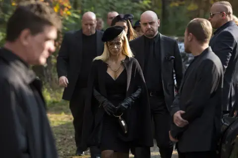 Kobieta w czerni, otoczona ochroniarzami, idzie na pogrzeb. Scena z filmu "Pitbull. Ostatni pies", obsada w żałobie.