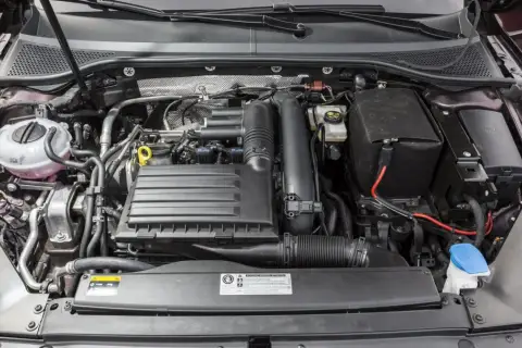 Silnik 1.4 TSI z widocznym zbiorniczkiem płynu chłodniczego, skrzynką bezpieczników i elementami układu dolotowego.