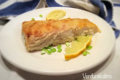 Un filetto di pesce persico cotto in padella, guarnito con spicchi di limone e erba cipollina. Perfetto per una ricetta pesce persico in padella al limone leggera e gustosa.