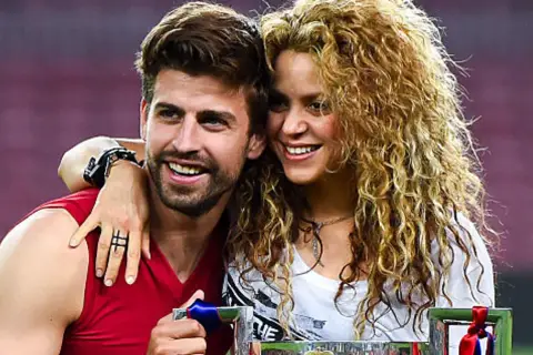Shakira i Piqué świętują sukces. Uśmiechnięci, blisko siebie, z pucharem w rękach.