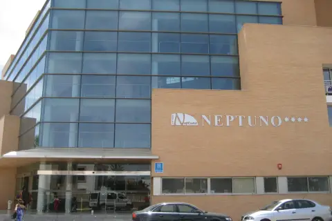 Fachada moderna del hotel Neptuno Roquetas de Mar, con amplios ventanales y detalles en ladrillo.