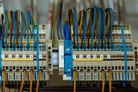 Zaciski elektryczne z kolorowymi przewodami tworzą skomplikowane przyłącze prądu.
