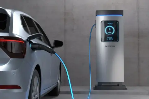 Srebrny samochód elektryczny podłączony do stacji ładowania. Zastanawiasz się, ile kosztuje ładowanie elektryka?