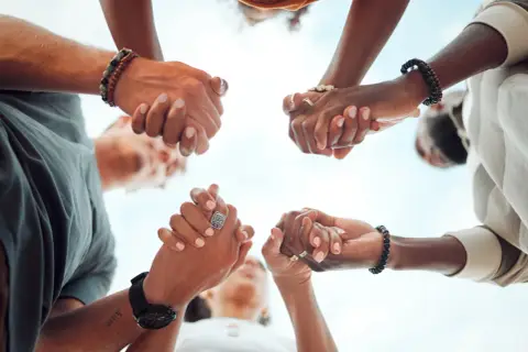 Hands clasped in unity, a circle of support. Ready to give, send, and go forward together.