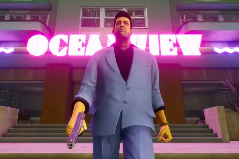 Tommy Vercetti z GTA Vice City Definitive Edition stoi przed neonowym napisem "OCEAN VIEW", trzymając pistolet.