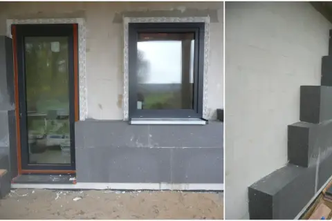 Budowa domu ze styropianu w toku. Widoczne okna, drzwi i szara izolacja termiczna.