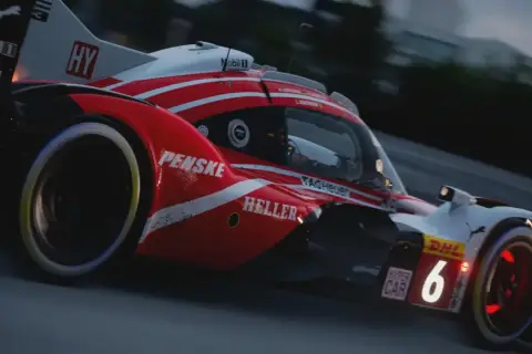 Wyścigówka z numerem 6 na torze, z logotypami Penske i DHL. Nowa aktualizacja Gran Turismo 7 przynosi emocje!