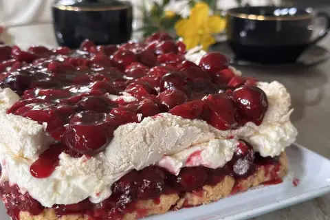 Sernik z wiśniami i bitą śmietaną, prawdziwa wiśniowa fantazja. Puszyste bezy, krem i soczyste owoce.