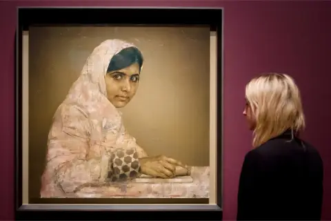 A striking **Malala Yousafzai portrait** shows her looking thoughtfully, her hands resting on a book. A woman observes the artwork.