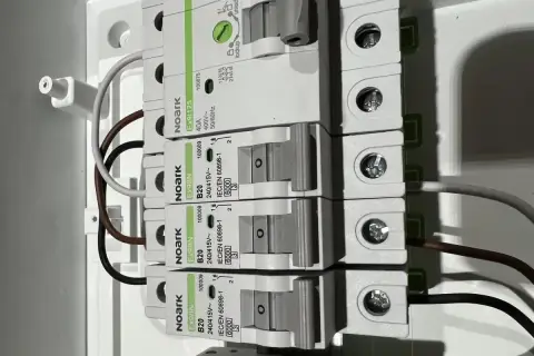 Budowa przewodu elektrycznego: zabezpieczenia nadprądowe Noark i podłączone przewody w rozdzielnicy.