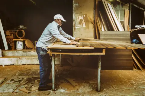 Artisan ajustant des planches de bois. Si votre cuisine est mal posée, quel recours ?