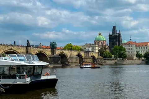 Rejs po Wełtawie czy warto? Widok na Most Karola z łodzią turystyczną.