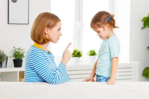 Matka karci dziecko, wskazując palcem.
