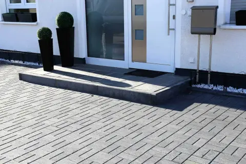 Nowoczesne aranżacje kostka brukowa wzory tworzą elegancki podjazd i schody przed domem.