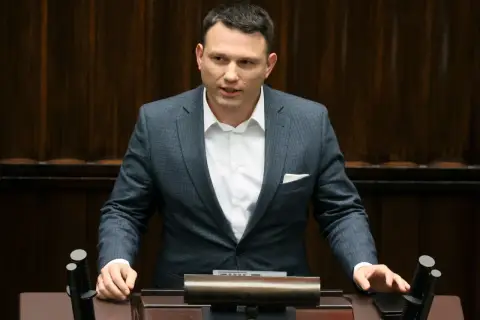 Sławomir Mentzen w garniturze przemawia, zastanawiając się, czy Sławomir Mentzen wykorzystuje AI do pisania swoich postów w kampanii prezydenckiej.