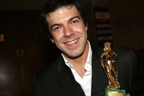 Favino giovane sorride con un premio David di Donatello dorato.