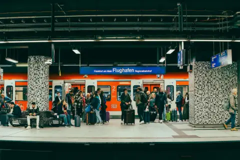 Ludzie z bagażami czekają na pociąg na stacji Frankfurt am Main Flughafen Regionalbahnhof.
