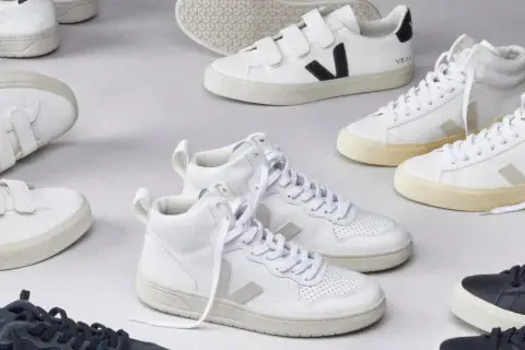 Białe i granatowe sneakersy Veja, niektóre na rzepy, inne sznurowane. Zobacz, co to za firma, która tworzy stylowe i ekologiczne obuwie.