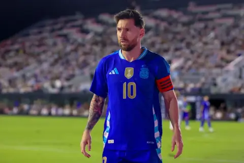 Messi w niebieskiej koszulce reprezentacji Argentyny, z numerem 10 na piersi, na tle trybun pełnych kibiców.