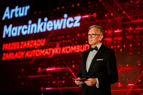 Artur Marcinkiewicz, prezes zarządu Zakłady Automatyki Kombud, przemawia na tle czerwonej scenografii.