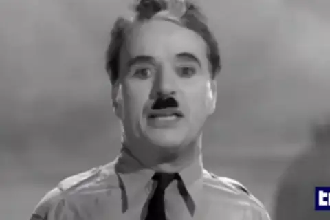Charlie Chaplin, con baffi e camicia, ricorda il suo discorso in "Il grande dittatore", un film che gli valse un Oscar onorario.