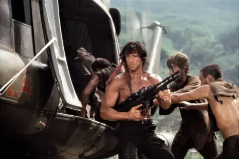 Rambo z karabinem wychodzi ze śmigłowca. Ile jest części Rambo? To pytanie zadaje sobie wielu fanów.